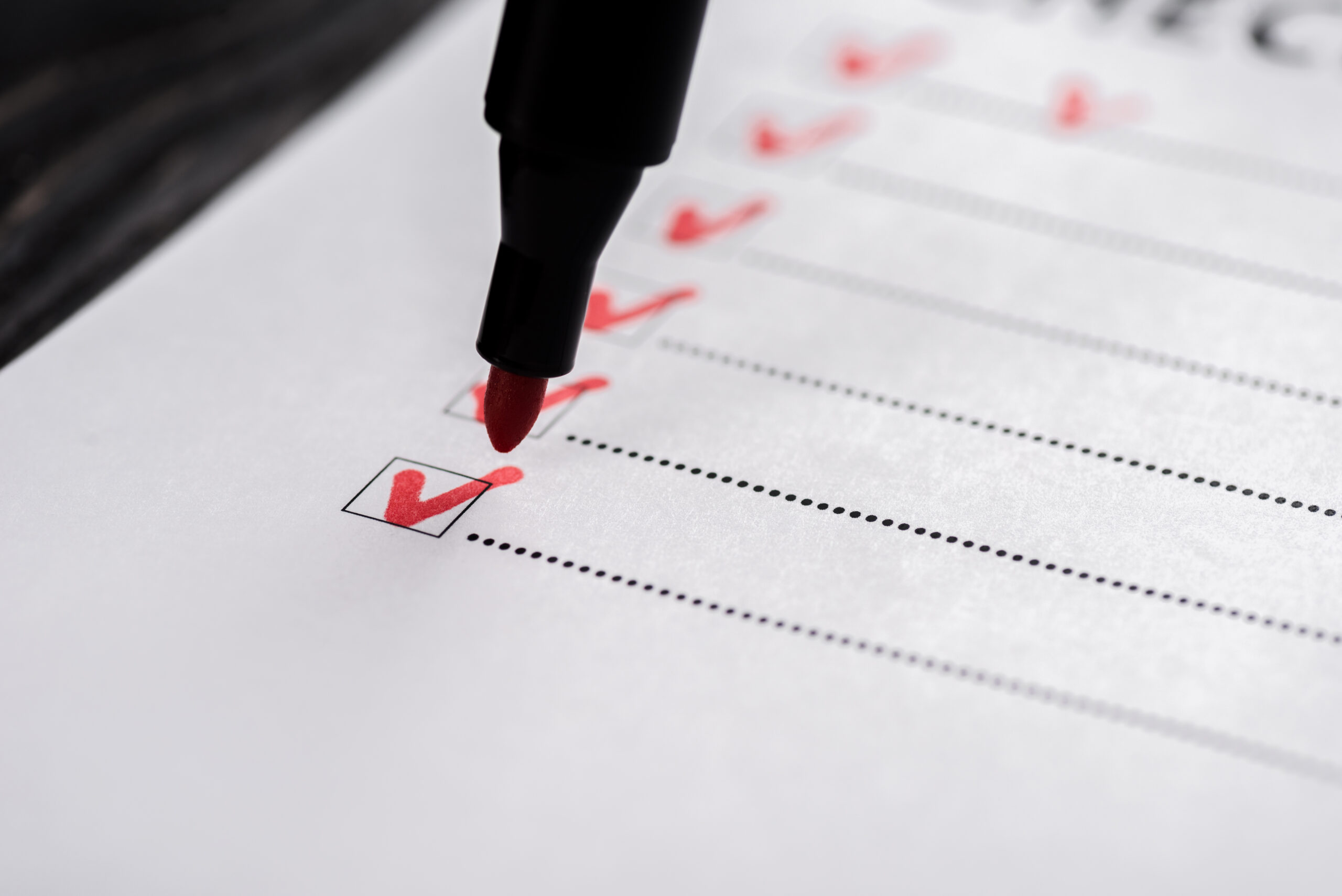 close up of checklist with ticks near red marker pen close up of checklist with ticks near red marker pen
